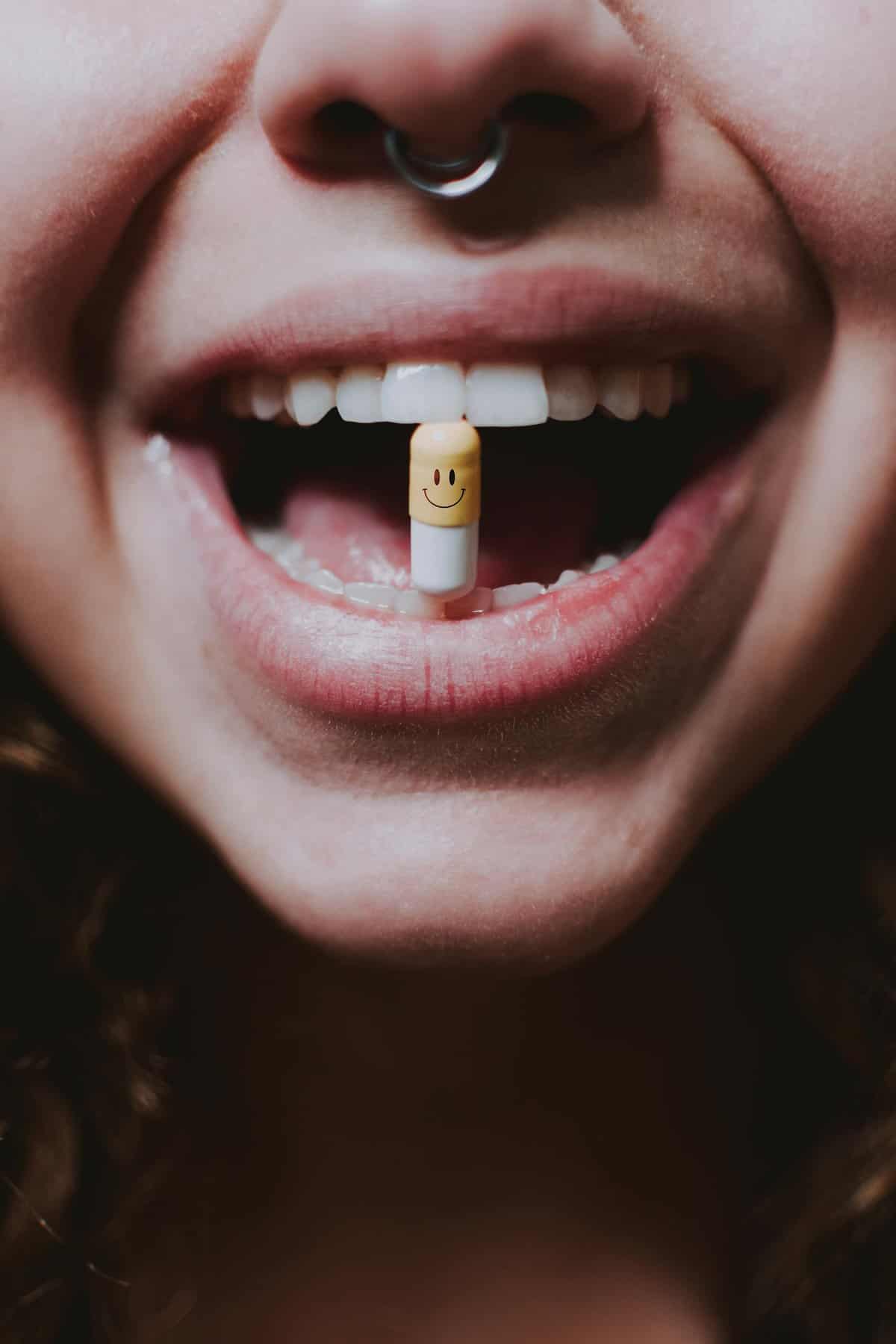 Faceless woman with THC microdose in her mouth.