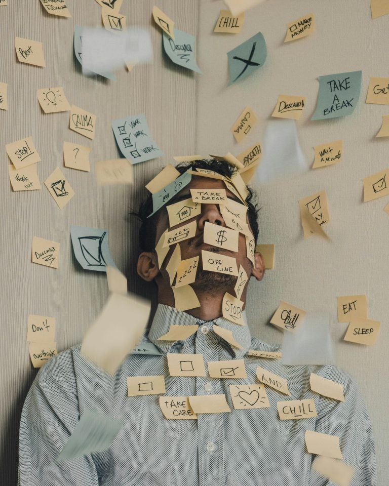 Man with parenting anxiety sticky notes covering face