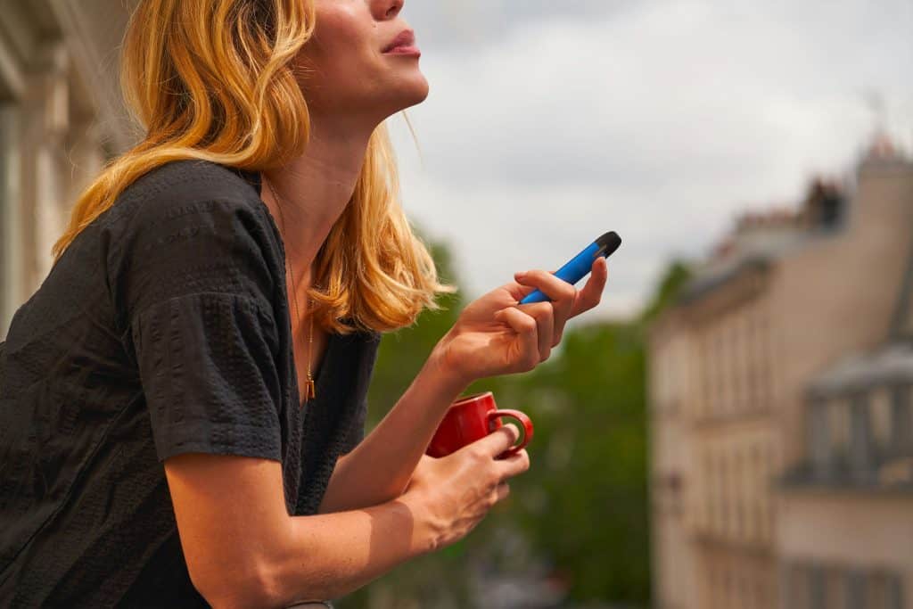 Woman using dry herb vaporizer